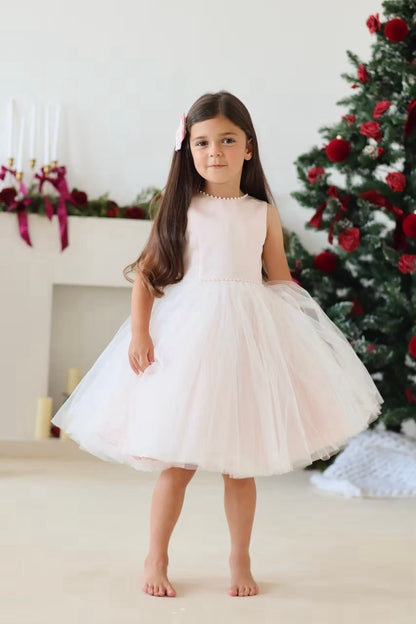 Sarah Louise Peach Pearl Ballerina Dress featuring a soft peach tone, pearl-trimmed neckline, full layered tulle skirt and statement V-back bow.