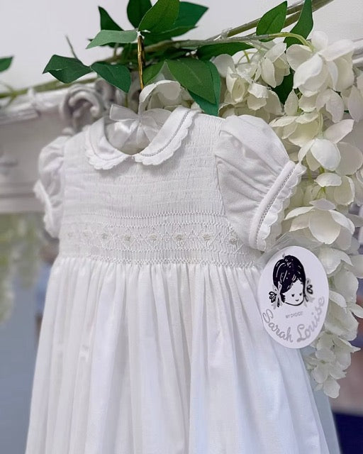 Sarah Louise Philippa Christening Gown & Bonnet featuring hand-smocked floral embroidery, pearl details, scalloped trims and a matching bonnet.