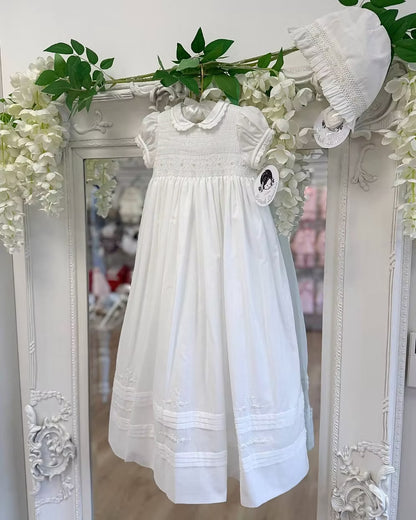 Sarah Louise Philippa Christening Gown & Bonnet featuring hand-smocked floral embroidery, pearl details, scalloped trims and a matching bonnet.