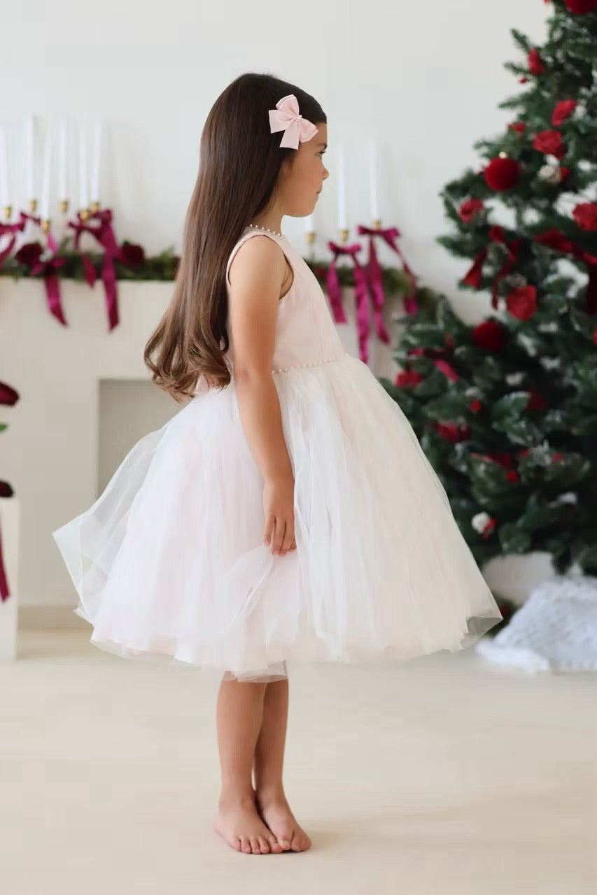 Sarah Louise Peach Pearl Ballerina Dress featuring a soft peach tone, pearl-trimmed neckline, full layered tulle skirt and statement V-back bow.