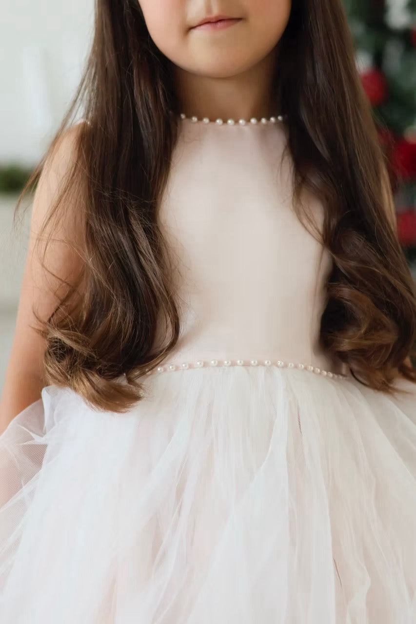 Sarah Louise Peach Pearl Ballerina Dress featuring a soft peach tone, pearl-trimmed neckline, full layered tulle skirt and statement V-back bow.