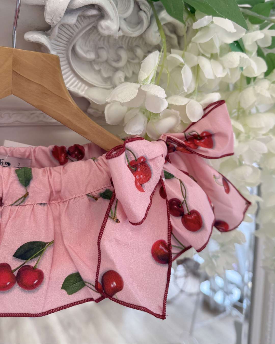 Phi pink jampants with a cherry print, a frill skirt overlay and two large side bows