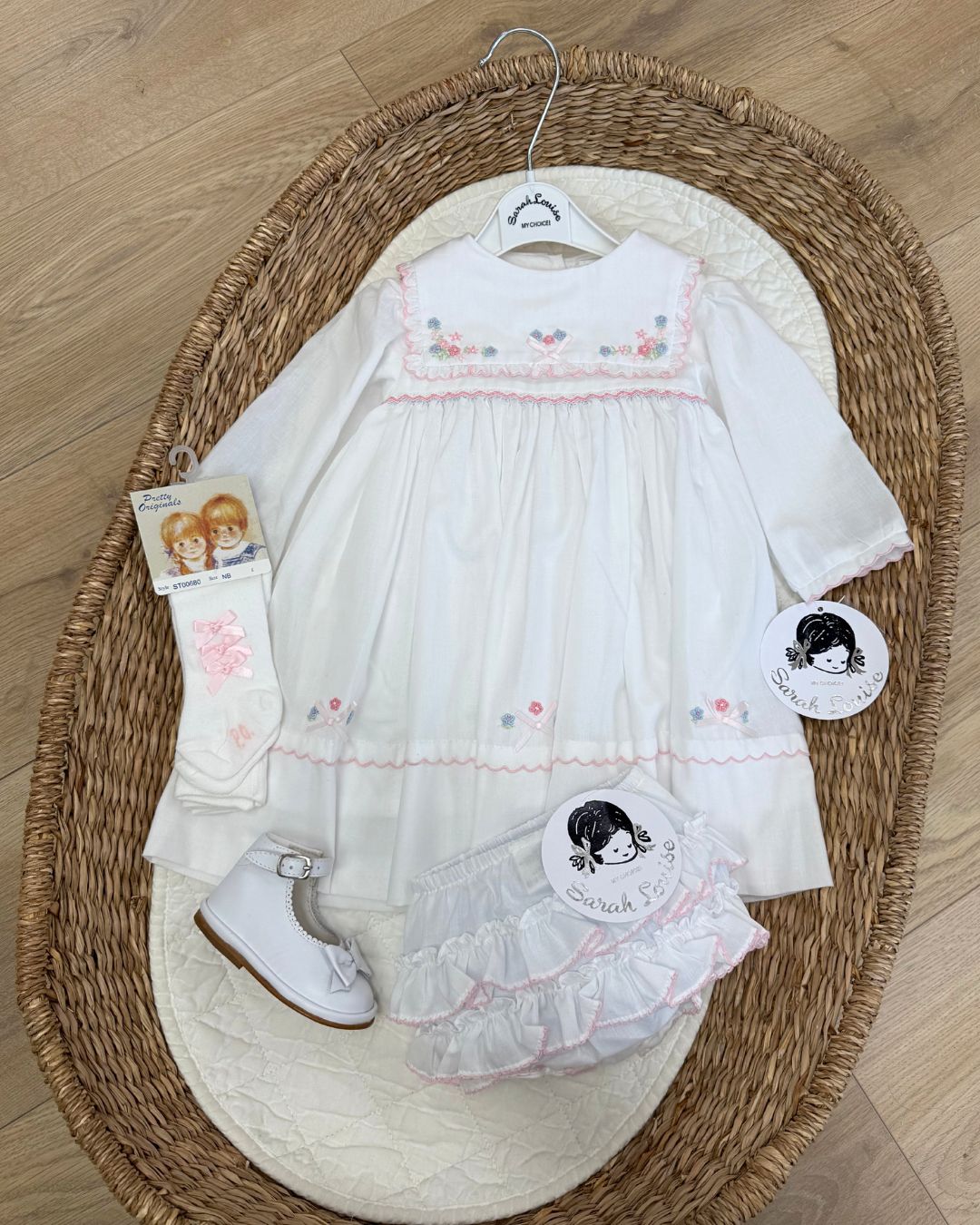 Sarah Louise Evelyn white girls smocked dress with pink and blue floral embroidery, square frill collar, satin bows and bow back tie.