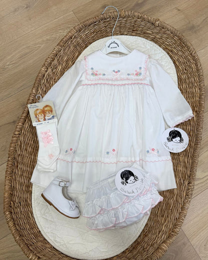 Sarah Louise Evelyn white girls smocked dress with pink and blue floral embroidery, square frill collar, satin bows and bow back tie.