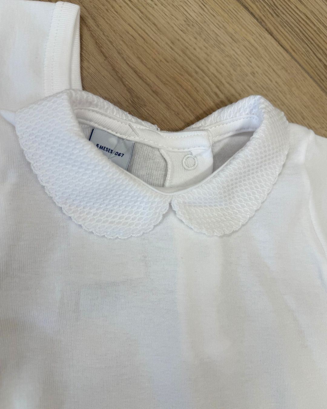 Babidu white unisex baby bodysuit with Peter Pan collar and coloured stitch trim.