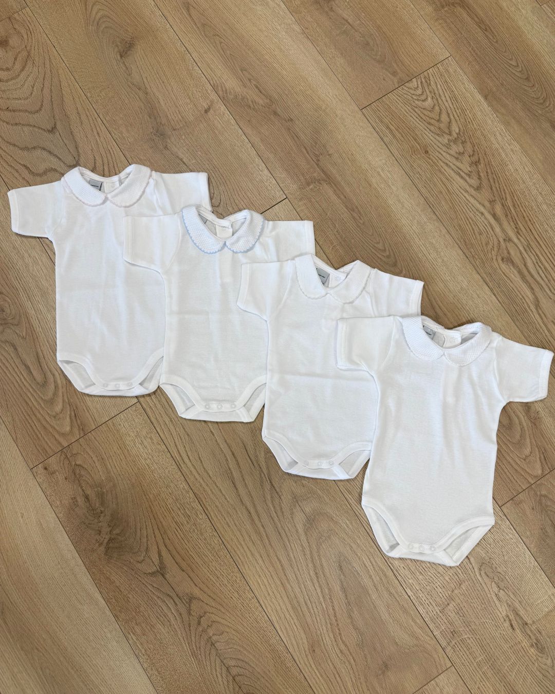 Babidu white unisex baby bodysuit with Peter Pan collar and coloured stitch trim.