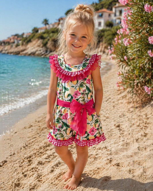 Babine Lemon Blossom Playsuit featuring a lemon and pink floral print, open back, tulle frill spine detail, gingham collar and statement bow tie.