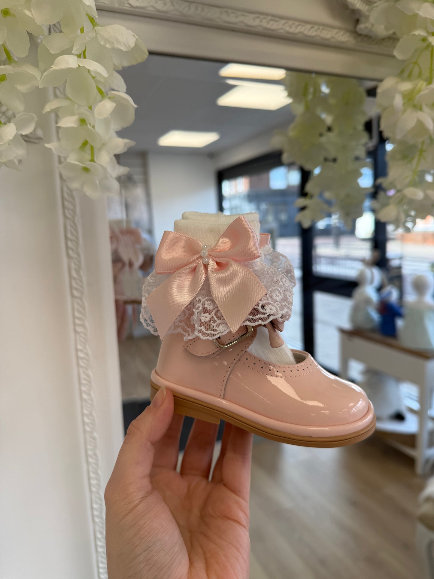 Crafted in soft white fabric, each pair features a delicate lace frill trim, finished with a pretty satin side bow and elegant pearl chain centre.