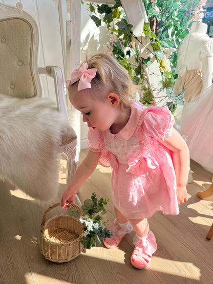 A soft rosy pink, this traditional Spanish-style dress is paired with matching jam pants. Adorned with a white chest panel featuring subtle stitch detailing, the dress is finished with pretty shoulder frills, two bow accents and a classic Peter Pan collar.