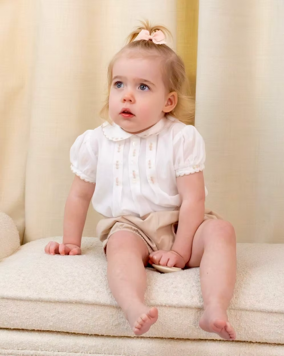 Sarah Louise x Little Lambs Heritage Girls Short Set featuring an ivory hand-smocked blouse with peach embroidery and neutral tailored shorts.