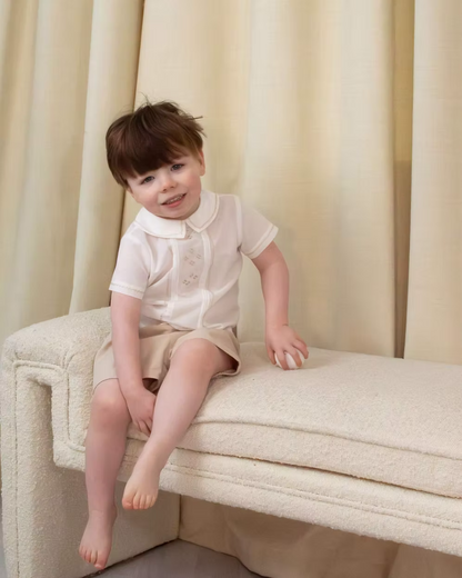 Sarah Louise x Little Lambs Heritage Boys Short Set featuring an ivory shirt with traditional detailing and tailored beige shorts.