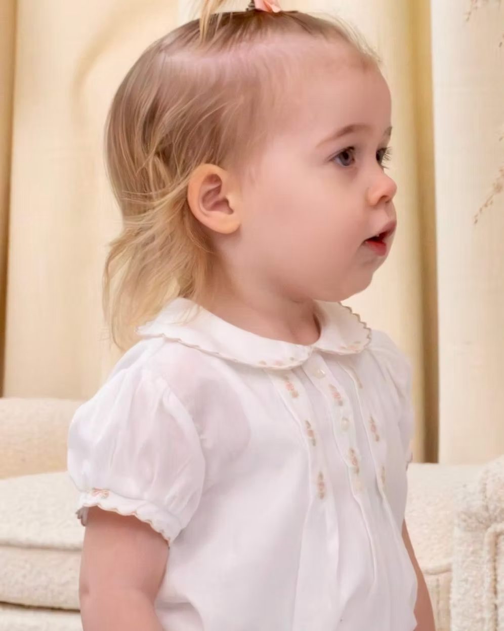 Sarah Louise x Little Lambs Heritage Girls Short Set featuring an ivory hand-smocked blouse with peach embroidery and neutral tailored shorts.