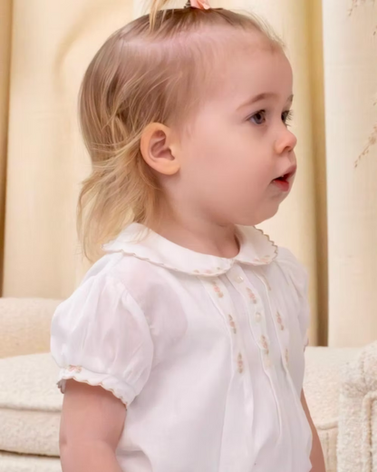 Sarah Louise x Little Lambs Heritage Girls Short Set featuring an ivory hand-smocked blouse with peach embroidery and neutral tailored shorts.
