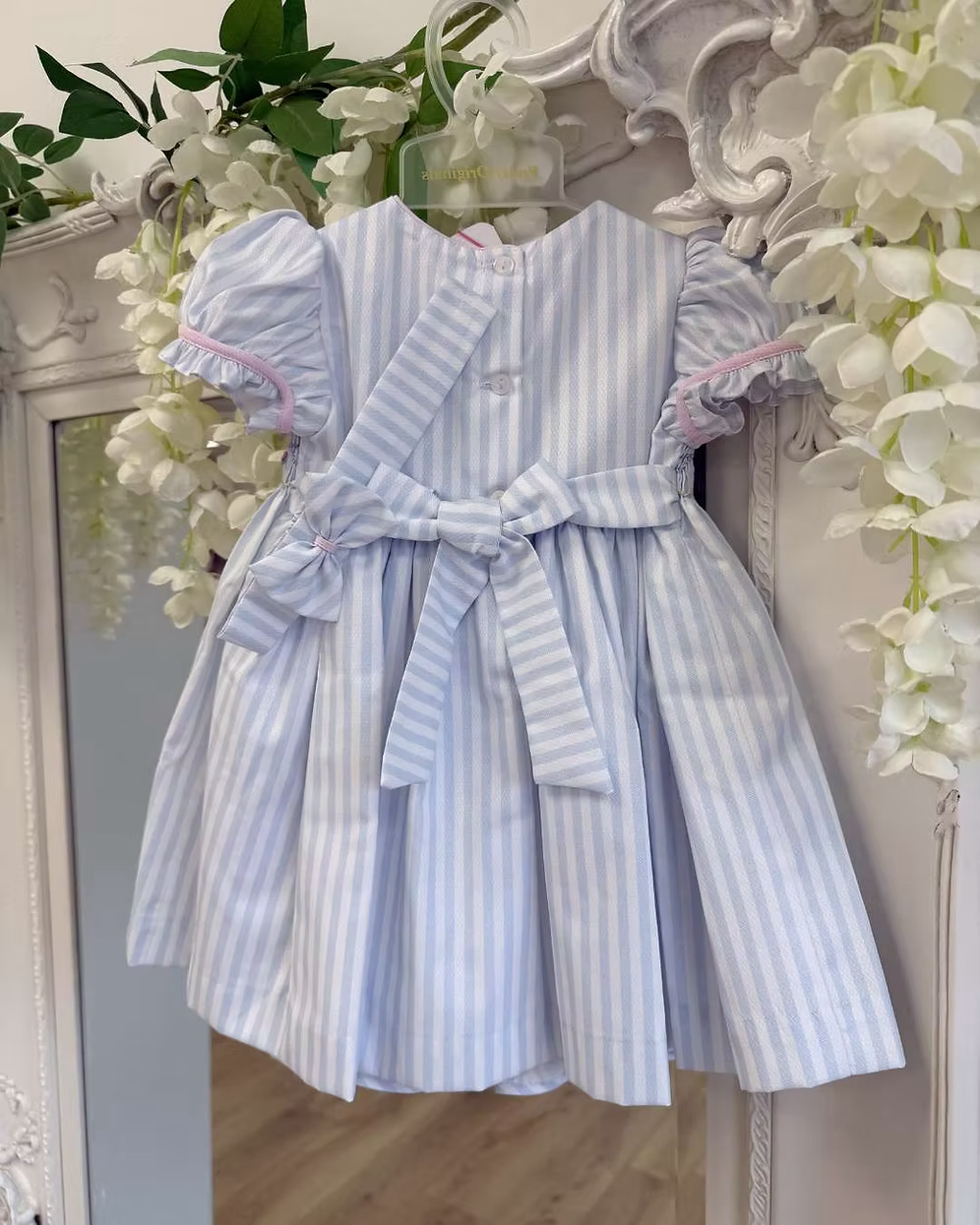 Pretty Originals Olivia Stripe Dress featuring blue and white stripes, hand-smocked rainbow embroidery, puff sleeves, matching bloomers and headband.