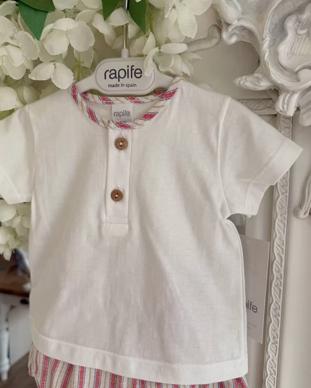 Designed with a linen-look striped short in a mix of red, blue, camel and soft off-white tones. Paired with a crisp white tee, finished with a contrasting striped trim to the neckline and classic wooden button detailing.