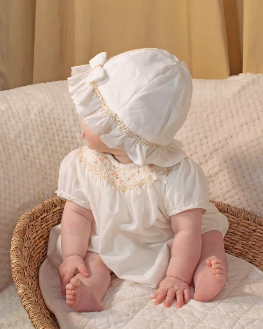 Sarah Louise x Little Lambs Heritage Bubble Romper featuring ivory fabric, hand-smocked floral embroidery, puff sleeves and a classic bubble shape.