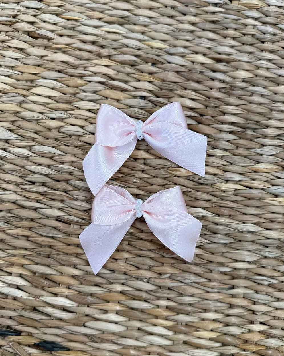 Featuring a small structured bow with a pearl-beaded centre, each clip is secured on a crocodile-style clasp for easy styling and a secure hold. 