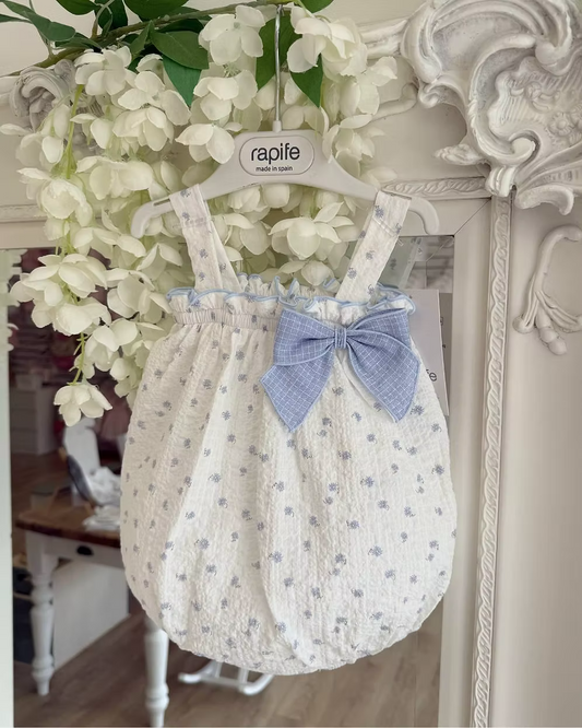 Blue Flower Romper. Designed in a soft white crinkle-textured fabric, this delicate piece is adorned with dainty blue floral detailing