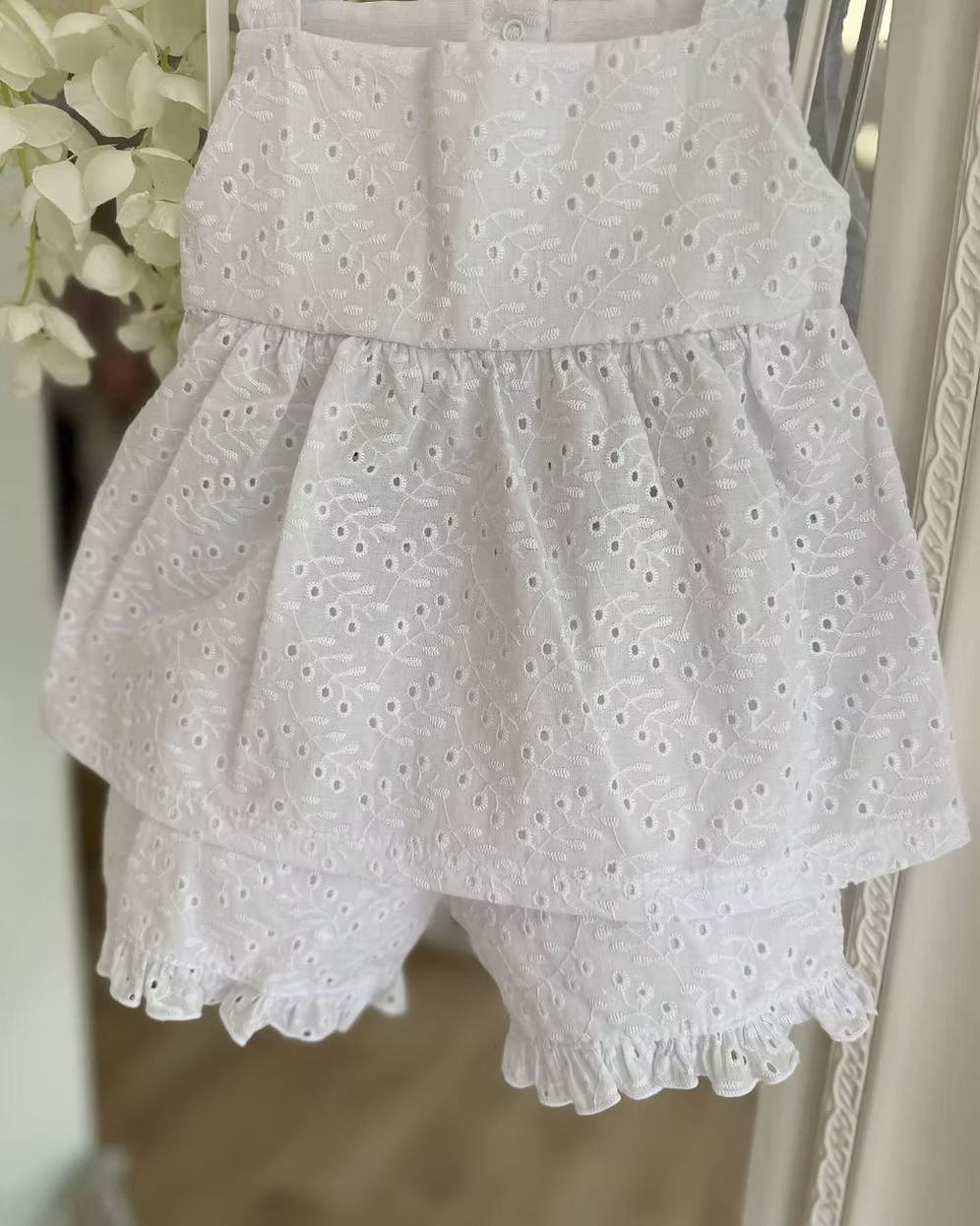 white broderie anglaise floaty top with matching frill trim shorts and shoulder ties