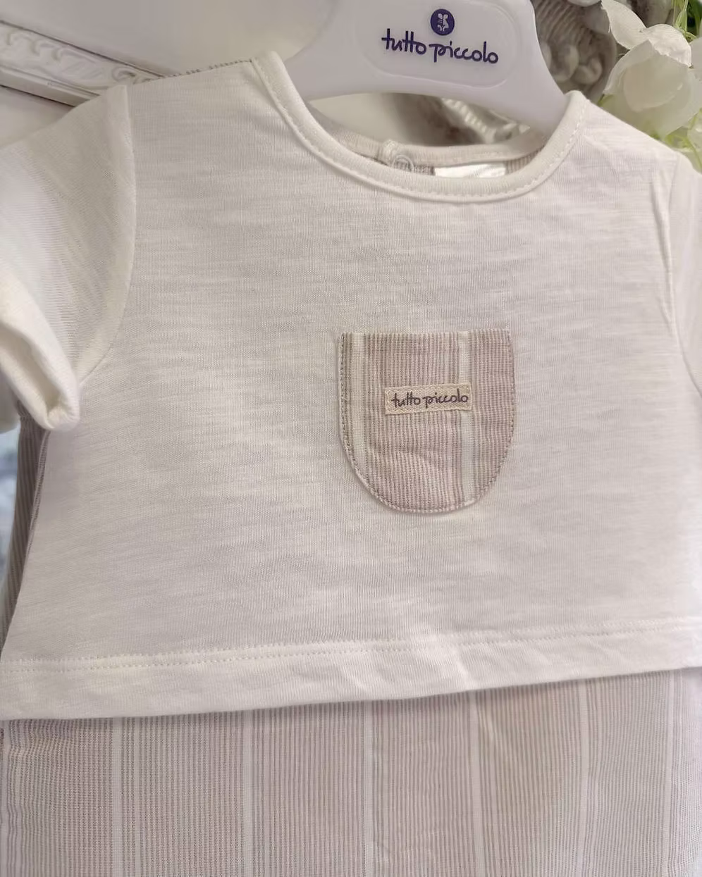 Tutto Piccolo Finn Romper featuring an ivory top, beige striped lower half, chest pocket with embroidered logo and lightweight summer design.