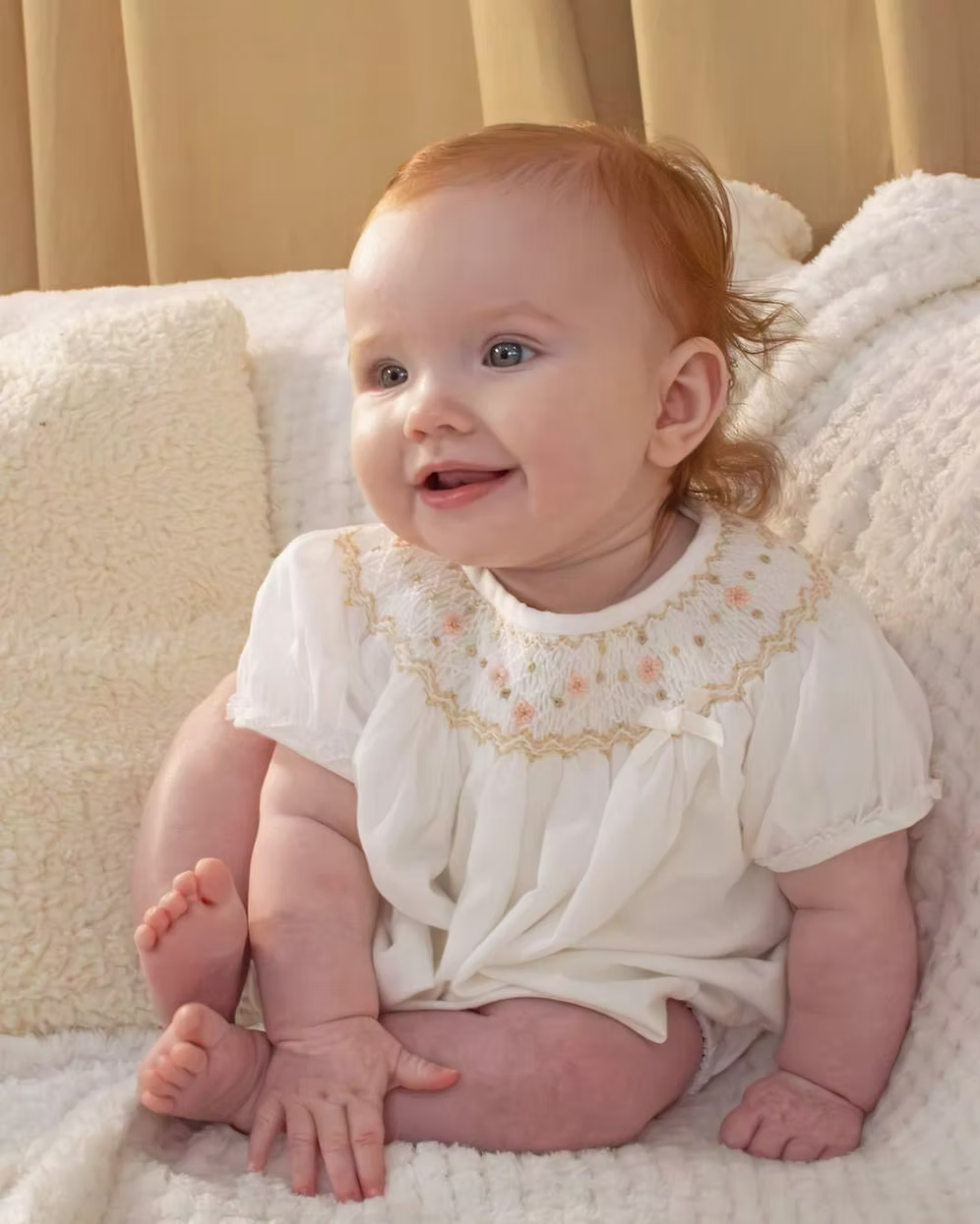 Sarah Louise x Little Lambs Heritage Bubble Romper featuring ivory fabric, hand-smocked floral embroidery, puff sleeves and a classic bubble shape.