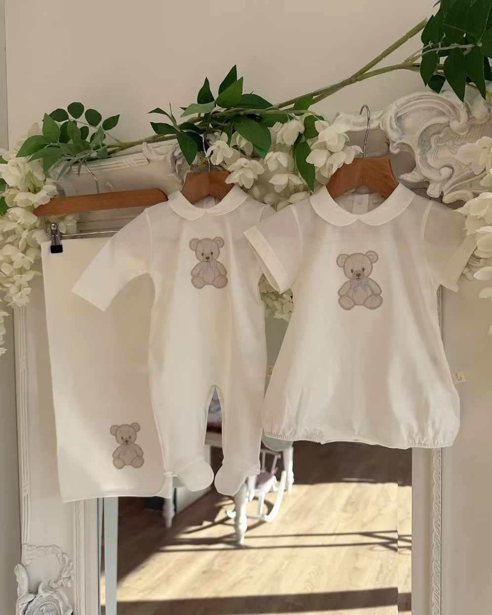 Baby Gi Teddy Shawl featuring soft cotton fabric, embroidered teddy bear detail and available in ivory, pink and blue colourways. Along side matching babygrow and romper.