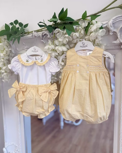 Deolinda Bumble Romper featuring buttery yellow gingham, a smocked chest panel, pleat detailing, button accents and a classic unisex design.