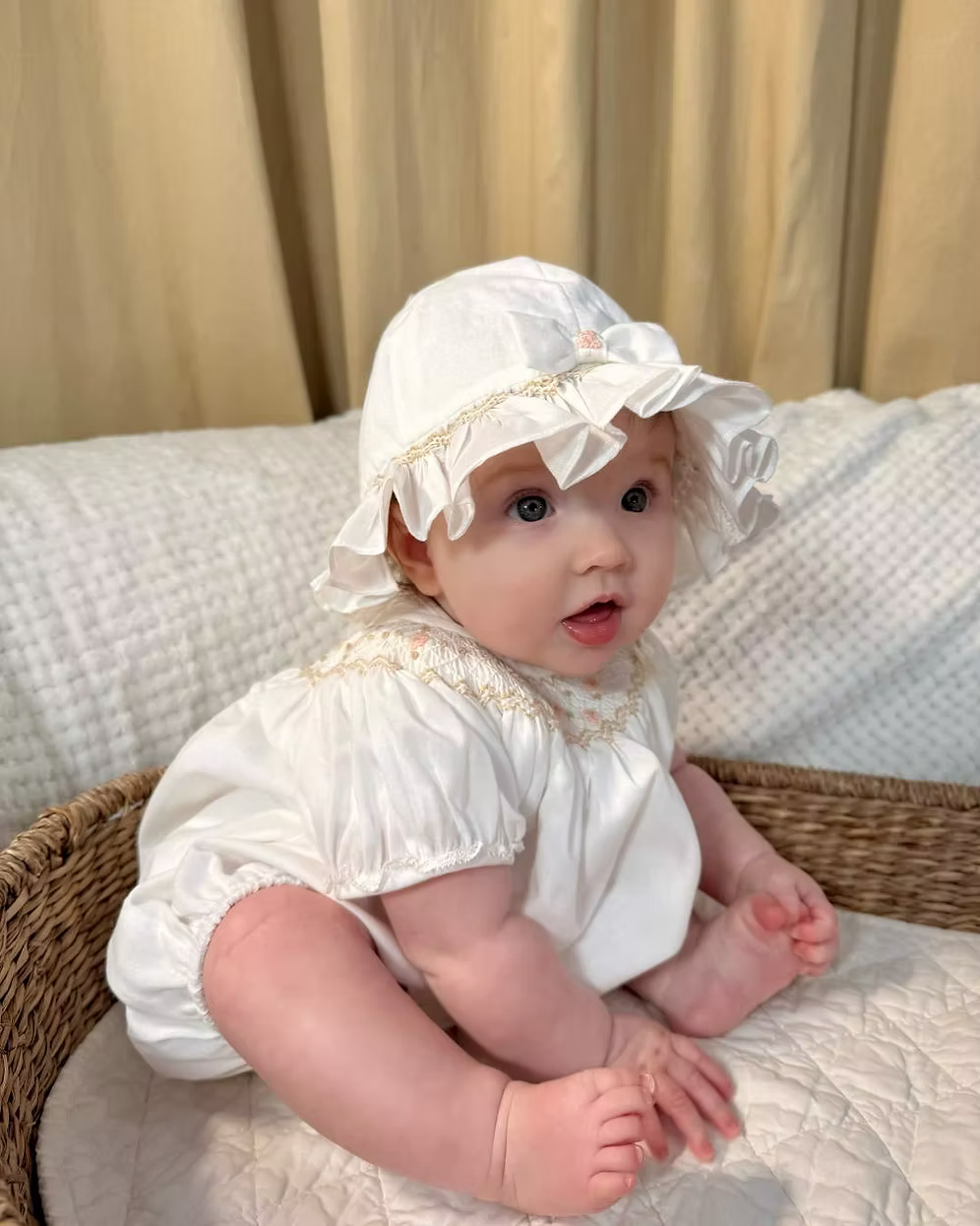 Sarah Louise x Little Lambs Heritage Bubble Romper featuring ivory fabric, hand-smocked floral embroidery, puff sleeves and a classic bubble shape.
