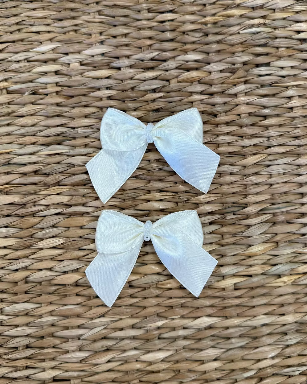 Featuring a small structured bow with a pearl-beaded centre, each clip is secured on a crocodile-style clasp for easy styling and a secure hold. 