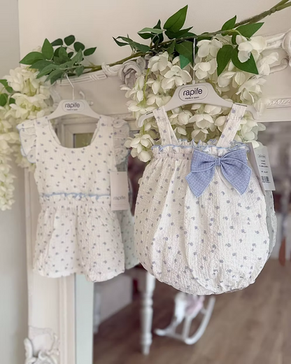 Blue Flower Romper. Designed in a soft white crinkle-textured fabric, this delicate piece is adorned with dainty blue floral detailing
