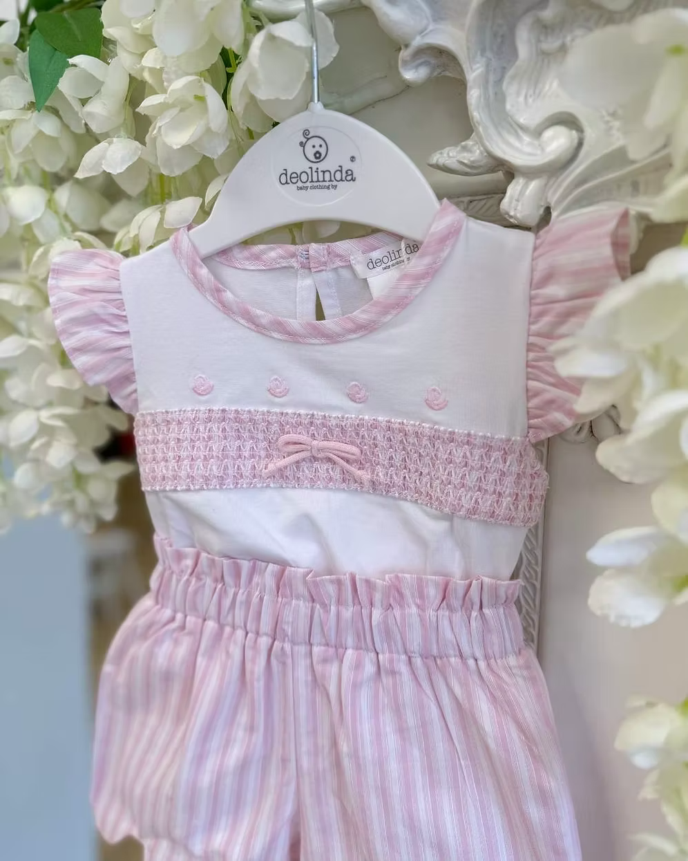 Deolinda California Pink Stripe Short Set featuring a white top with pink smocking, rosebud embroidery, bow detail and pink striped shorts.