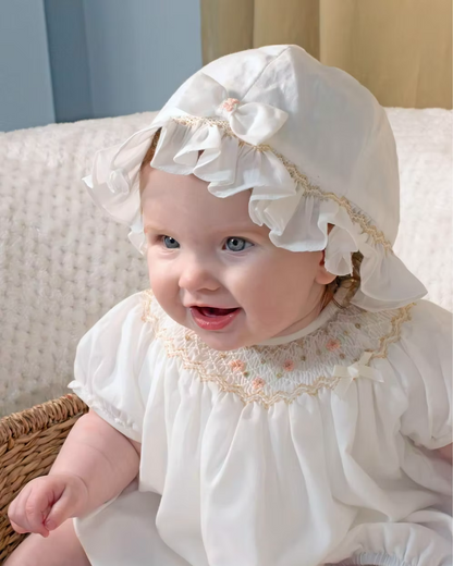 Sarah Louise x Little Lambs Heritage Bubble Romper featuring ivory fabric, hand-smocked floral embroidery, puff sleeves and a classic bubble shape.