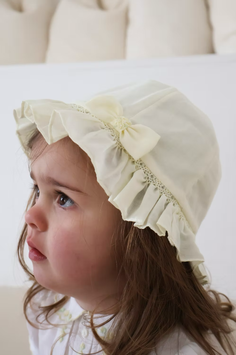 Sarah Louise Girls Sun Hat featuring hand-smocked trim, bow detail and a classic design. Available in white, pink and lemon.