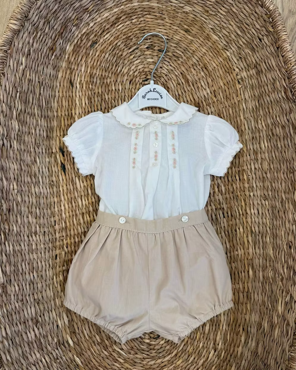 Sarah Louise x Little Lambs Heritage Girls Short Set featuring an ivory hand-smocked blouse with peach embroidery and neutral tailored shorts.