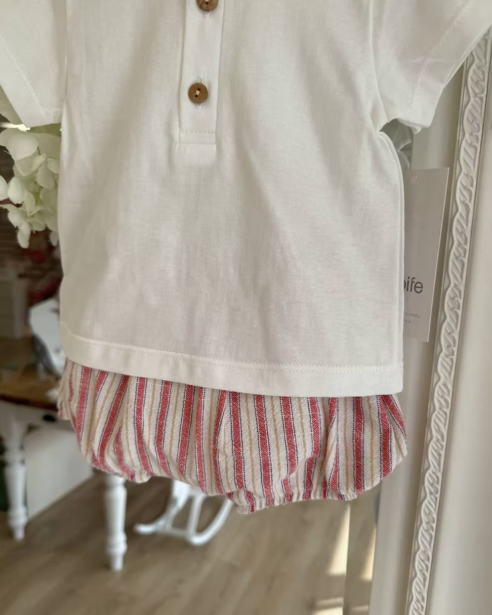 Designed with a linen-look striped short in a mix of red, blue, camel and soft off-white tones. Paired with a crisp white tee, finished with a contrasting striped trim to the neckline and classic wooden button detailing.