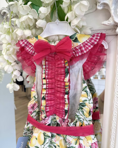 Babine Lemon Blossom Playsuit featuring a lemon and pink floral print, open back, tulle frill spine detail, gingham collar and statement bow tie.