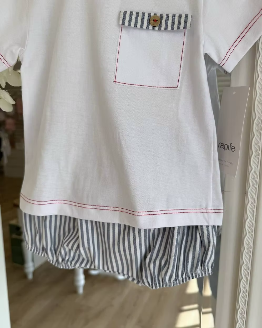 Featuring soft navy striped shorts paired with a fresh white tee. Beautifully detailed with subtle red stitch trims and a chest pocket finished with a navy stripe flap and wooden button.