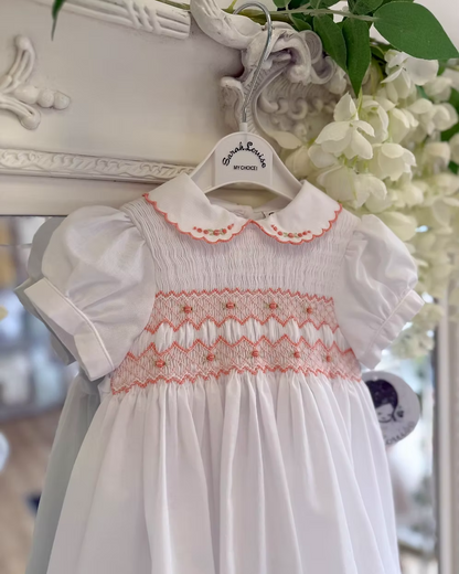White smocked dress with peach smocking, embroidered florals and scalloped hems