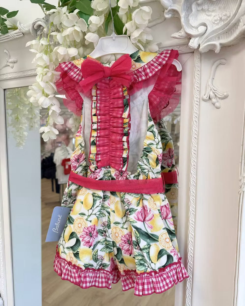 Babine Lemon Blossom Playsuit featuring a lemon and pink floral print, open back, tulle frill spine detail, gingham collar and statement bow tie.