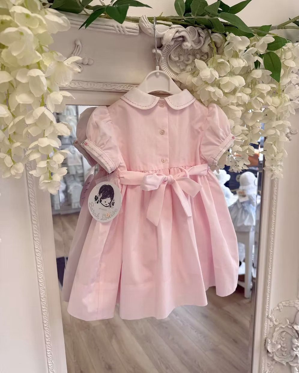 Sarah Louise Blair Pink Smock Dress featuring hand-smocked embroidery, pintuck detailing, embroidered Peter Pan collar, full skirt and bow back.