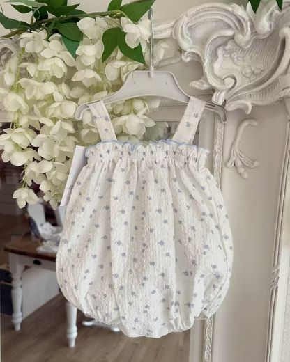 Blue Flower Romper. Designed in a soft white crinkle-textured fabric, this delicate piece is adorned with dainty blue floral detailing