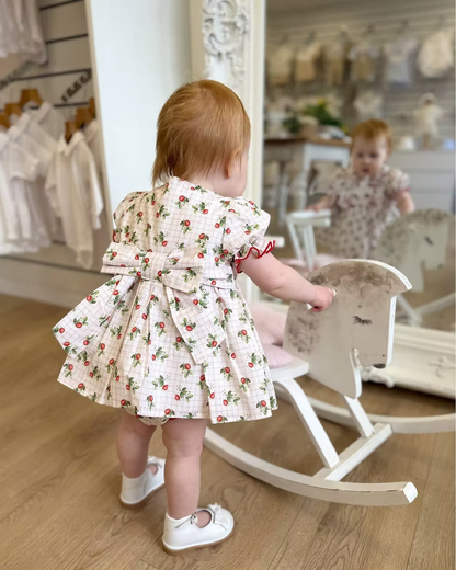 Off-white and pink check baby dress with strawberry print, frill chest detail, puff sleeves, red stitch trims, matching pants, and bow back fastening.