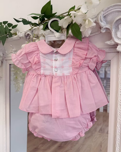 A soft rosy pink, this traditional Spanish-style dress is paired with matching jam pants. Adorned with a white chest panel featuring subtle stitch detailing, the dress is finished with pretty shoulder frills, two bow accents and a classic Peter Pan collar.