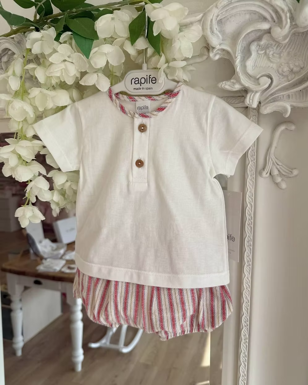 Designed with a linen-look striped short in a mix of red, blue, camel and soft off-white tones. Paired with a crisp white tee, finished with a contrasting striped trim to the neckline and classic wooden button detailing.