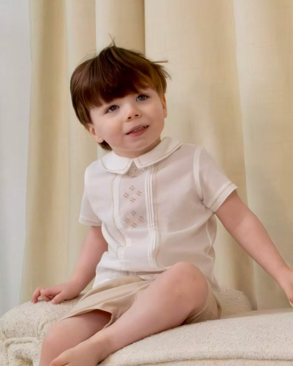 Sarah Louise x Little Lambs Heritage Boys Short Set featuring an ivory shirt with traditional detailing and tailored beige shorts.