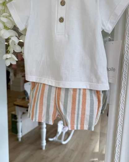 featuring striped shorts in soft off-white with pops of green and orange. Paired perfectly with a crisp white tee, finished with a simple wooden button neckline