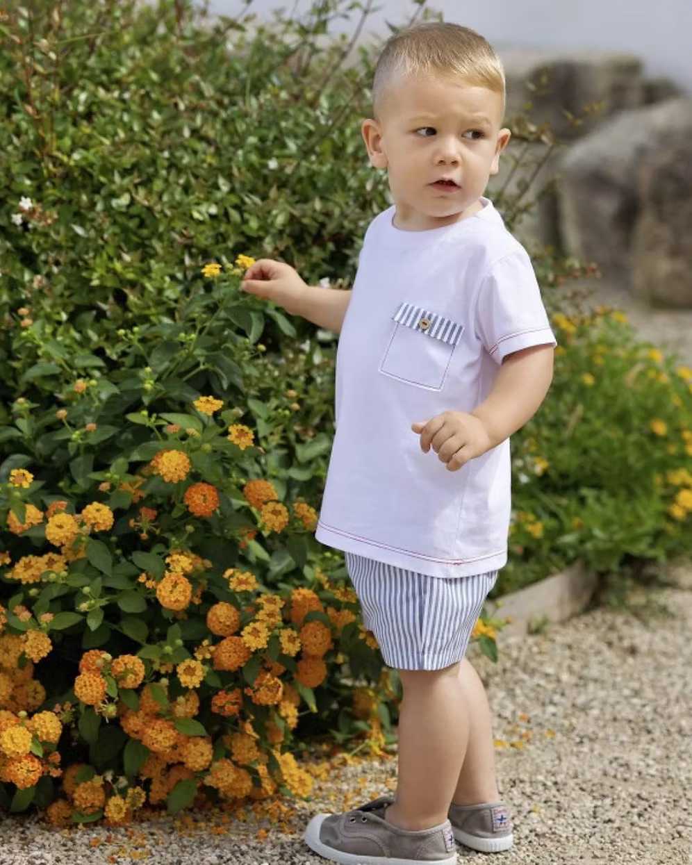Featuring soft navy striped shorts paired with a fresh white tee. Beautifully detailed with subtle red stitch trims and a chest pocket finished with a navy stripe flap and wooden button.