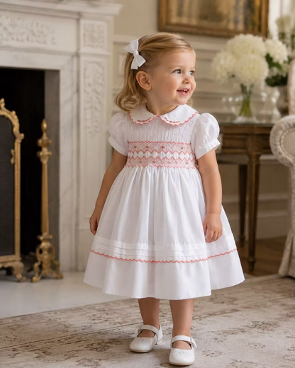 White smocked dress with peach smocking, embroidered florals and scalloped hems
