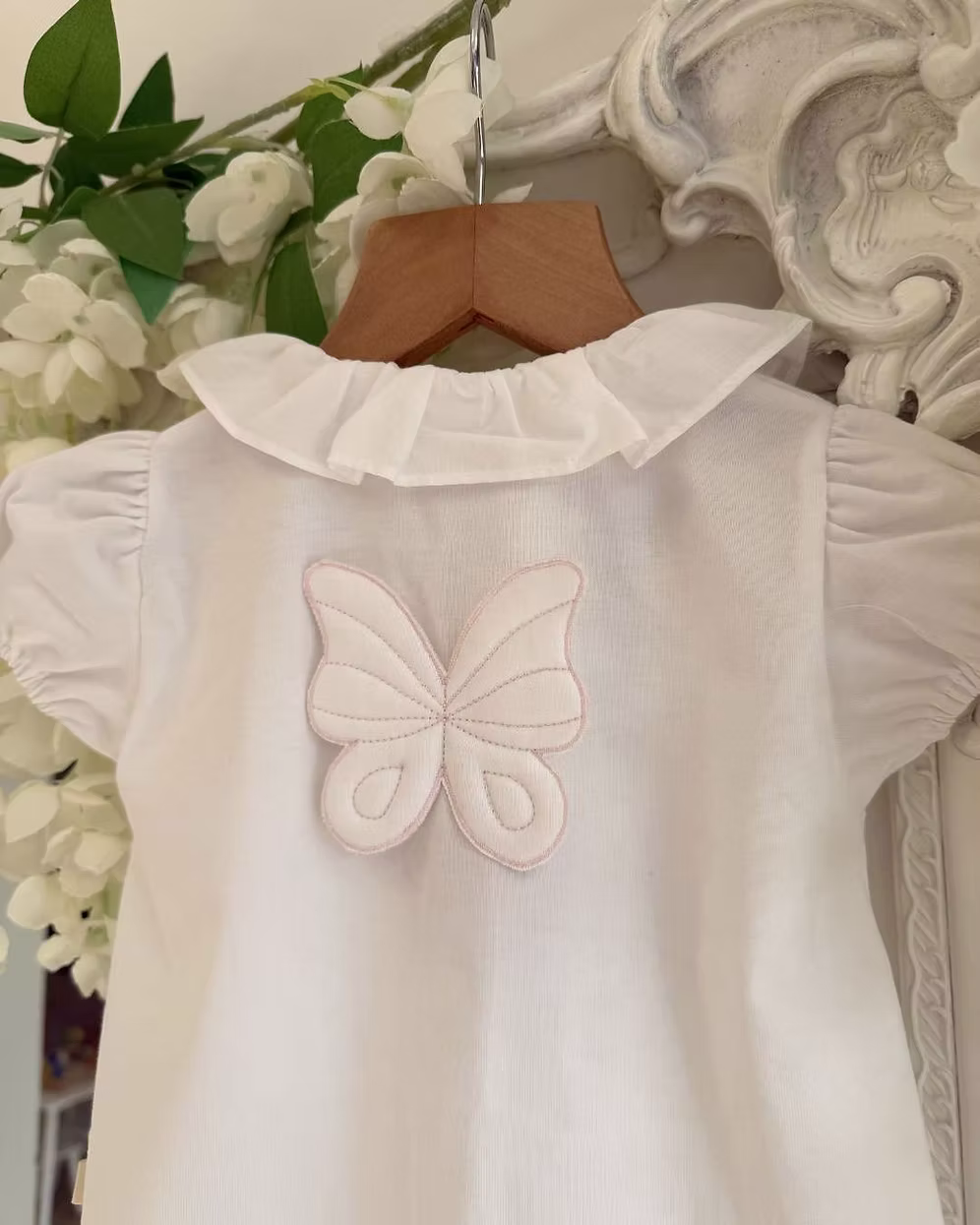 Baby Gi Butterfly Back Romper featuring a white bubble design, oversized butterfly back detail, pink embroidered trims and a frill collar.