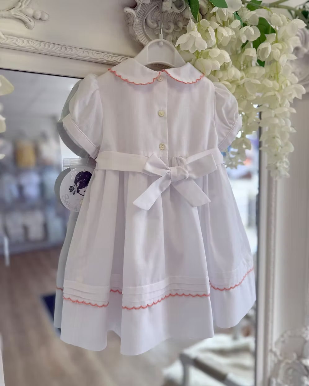 back of white dress with button and bow back fastening